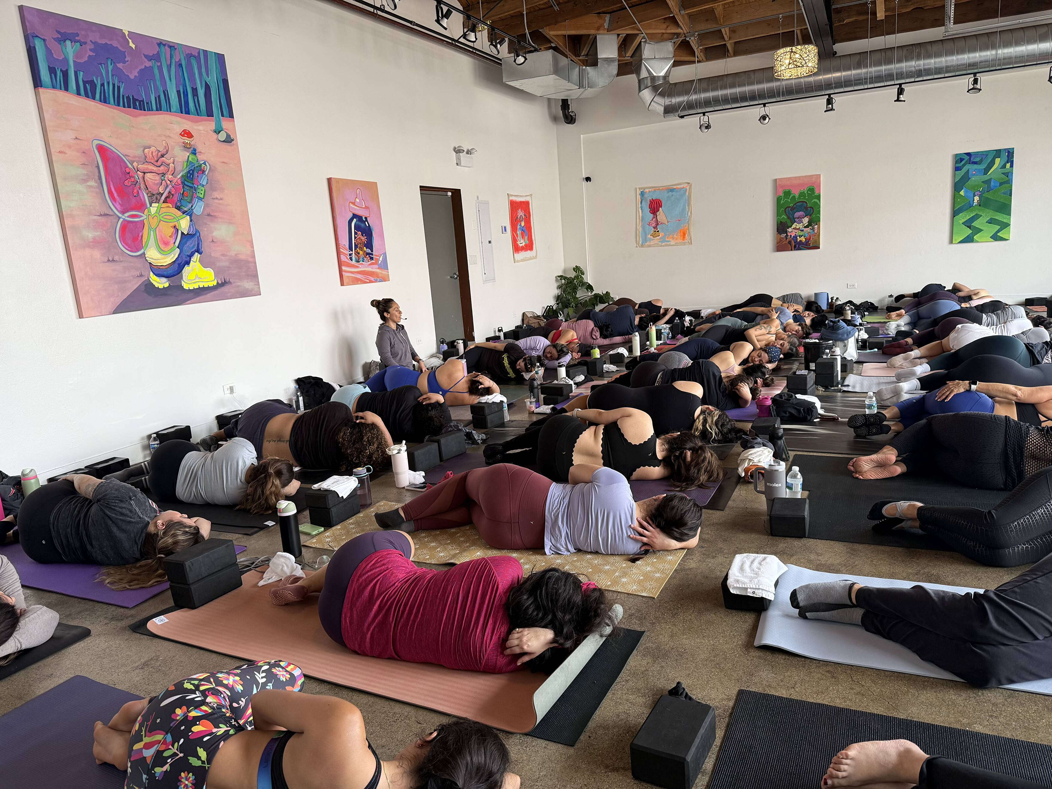 A diverse group of women participating in a community yoga class outdoors